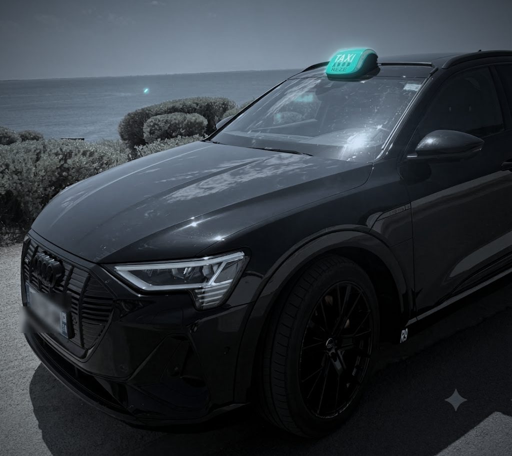 L'Audi Q8 e-tron Sportback de KM Taxi garée face à la mer, lumineux allumé